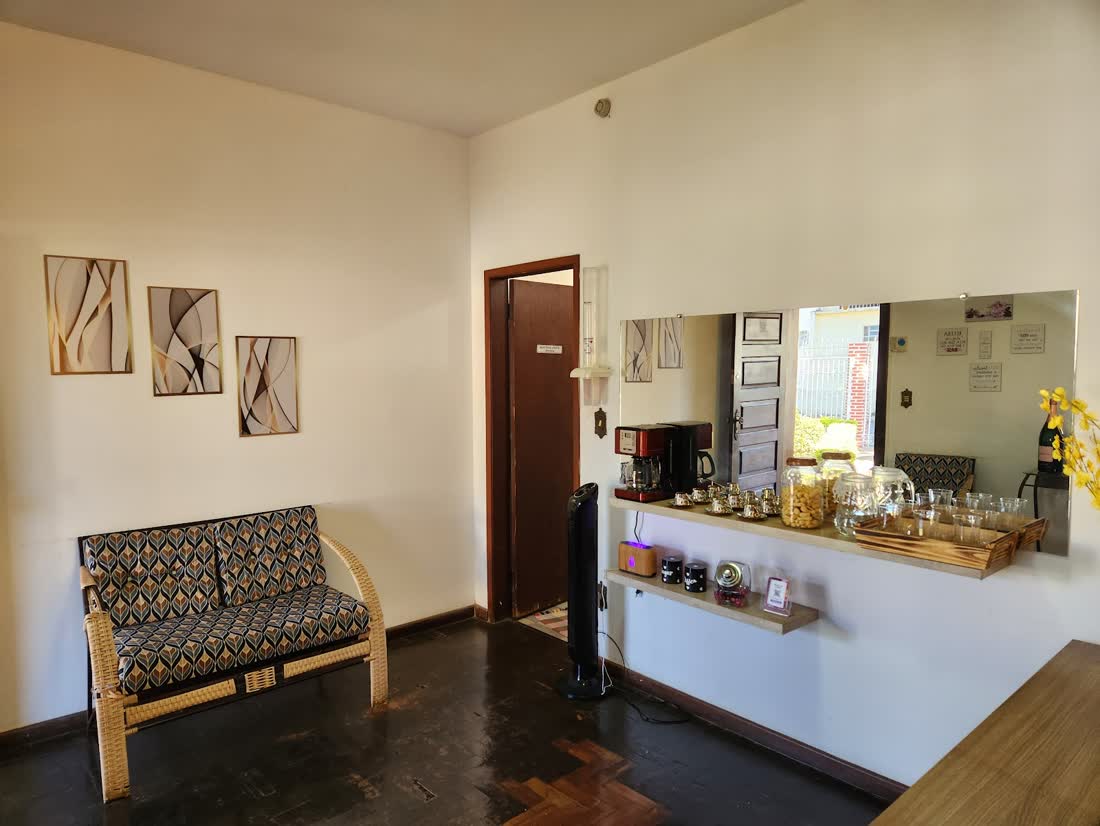 Recepção da Perfil Estética com sofá de fibra, quadros e o cantinho do café